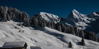 Vue sur les montagnes du Grand Bornand et un chalet après une chute de neige